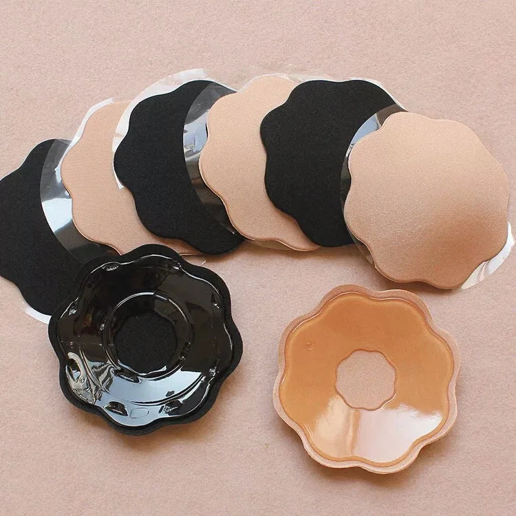 Flower-shaped silicone nipple covers in nude and black tones fanned out on display