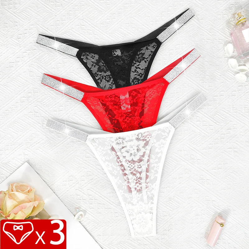 Three lace thong panties—black, red, and white—with rhinestone side straps on textured backdrop
